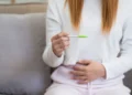 امرأة تمسك اختبار الحمل المنزلي