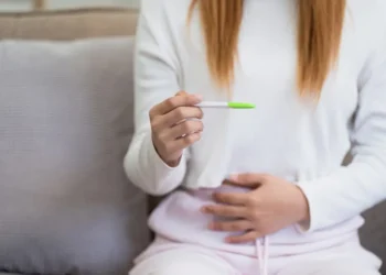 امرأة تمسك اختبار الحمل المنزلي