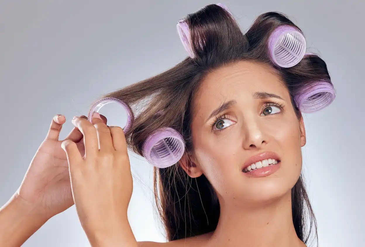 امرأة تعاني بسبب استخدام لفافات الشعر