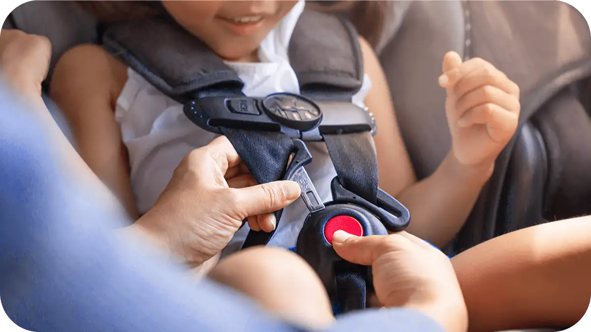 أم تثبت كرسي السيارة للطفل