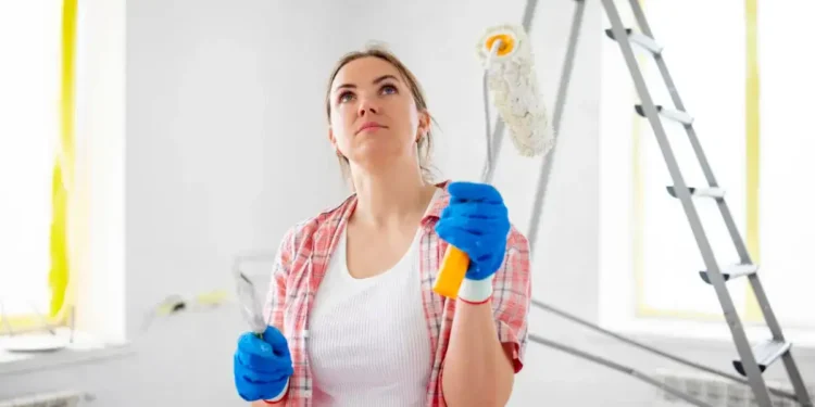 امرأة تقوم بدهان الجدران وتفكر كيف تتفادى الأخطاء