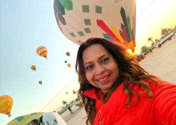 فادية عبود - رئيسة تحرير سوبر إيف - في لحظة تأمل وسط مشهد من البالونات الطائرة، ترمز لحرية المرأة المصرية في مواجهة القوالب النمطية